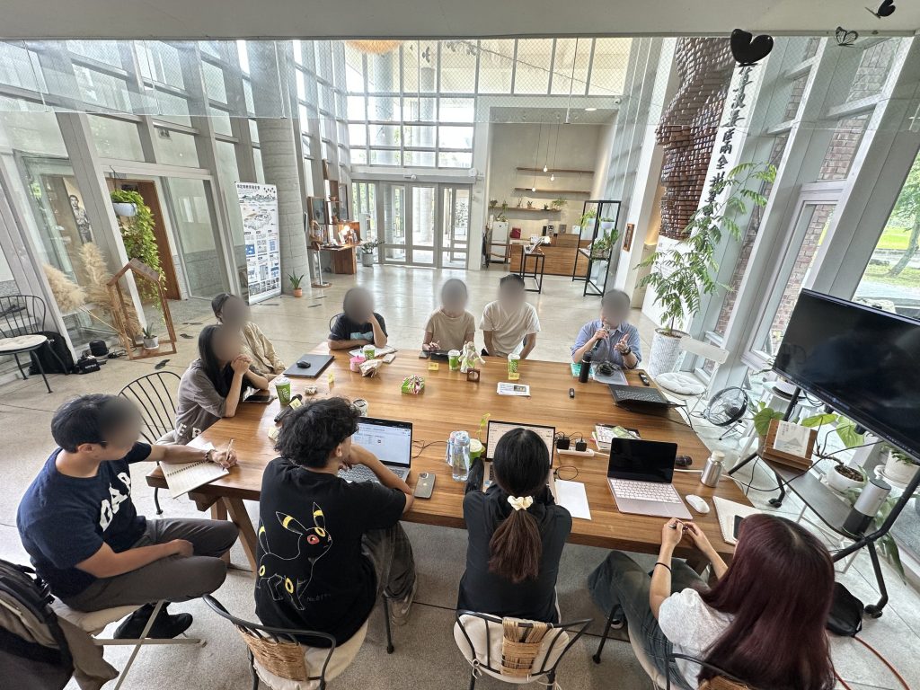 實習生與基金會工作人員在紀念館大廳圍坐長桌討論